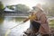 Happy Asia Chinese little boy toddler child play with his mother mom by lake holding string net catch fish carefree childhood