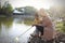 Happy Asia Chinese little boy toddler child play with his mother mom by lake holding string net catch fish carefree childhood