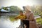 Happy Asia Chinese little boy toddler child play with his mother mom by lake holding string net catch fish carefree childhood