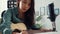 Happy asia woman songwriter play acoustic guitar listen song from smartphone think and write notes lyrics song in paper sit in