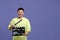 Happy asian actor with clapperboard on purple background, space for text. Film industry