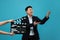 Happy asian actor performing while second assistant camera holding clapperboard on light blue background. Film industry