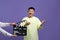 Happy asian actor performing while second assistant camera holding clapperboard on purple background. Film industry