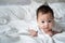 Happy asian baby infant learning to crawl on white soft bed. 3 months old baby facial expression. lovely and smile baby. cute kid