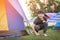 Happy asian boy in camping tent in summer forest
