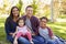 Happy Asian Caucasian mixed race family, portrait in a park