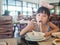 Happy Asian child eating delicious noodle with chopstick
