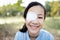 Happy asian child girl cover with blindfolded bandaged eye after surgery or treatment of strabismus,lazy eye, hygienic,prevent