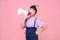 Happy Asian child girl shouting into megaphone making announcement in isolated on pink background