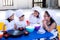 Happy Asian children girls and boy wear white uniform cooking and hat cooking.