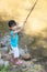 Happy Asian Chinese little girl angling with fishing rod