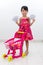 Happy Asian Chinese little girl pushing toy trolley holding cash