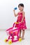 Happy Asian Chinese little girl pushing trolley holding credit c