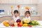 Happy Asian Chinese little sisters with fruit and vegetable