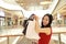 Happy Asian Chinese modern fashionable woman shopping bags in a mall store casual buyer smile laugh consumption on sale promotion