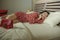 Happy Asian Chinese woman in chic dress lying happy in room bed with luggage after hotel check in talking on mobile phone excited
