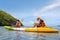 Happy asian couple kayaking together on the beautiful sea or canoe at tropical bay