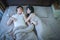 Happy Asian couple in love, sleeping together on bed