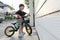 Happy asian cute boy riding balance bike on street