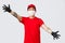 Happy asian delivery guy in red uniform, cap, stretching hands sideways to show large package, big parcel. Courier from