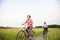 Happy Asian elderly seniors couple biking in the park with blue