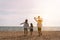 Happy asian family on the beach in holiday. of the family holding hands, Son and daughter piggyback on parents.They are having fun