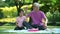 Happy Asian family child having fun and playing with her grandfather in the park