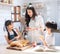 Happy asian family in the kitchen. mother and son and daughter spread strawberry yam on bread, leisure activities at home