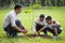 happy asian Family, parents and their children plant sapling tree together in park . father mother and son,boy having fun and