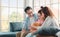 Happy asian family sitting on sofa and playing dolls with their daughter down syndrome child in living room at morning time,