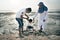 Happy asian family wearing casual and playing with mud at the muddy beach