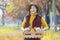 Happy Asian farmer girl carrying produce harvest with homegrown organics apple, squash and pumpkin with fall color from maple tree