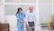 Happy asian female doctor helping elderly patient walking with cane or walking stick at home.Nures or caregiver assistance and