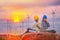 Happy Asian Female and male engineers writing the note pad on Wind turbine power generator with world map at twilight