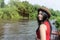 Happy Asian girl red shirt and brown hat on the river in nature background