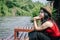 Happy Asian girl red shirt and brown hat on the river in nature background