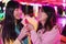 Happy asian girls eating candy sweets ice cream at amusement park - Young trendy friends having fun together- Tech, friendship and