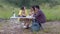 Happy asian group of friends camping to picnic in the mountain in vacation, man and woman eating and talking in party.