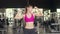 Happy Asian healthy sport woman trainer with sportswear smiling looking at camera show arms muscle after workout in gym, People