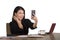 Happy Asian Korean businesswoman taking selfie photo with mobile phone at corporate company office desk smiling playful in female