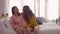 Happy Asian lesbian lgbt couple enjoy entertainment in living room. Beautiful women lying on a sofa listen to music on smartphone.