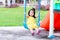 Happy Asian little child girl aged 3 years old is playing in a blue swing.