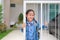 Happy asian little girl in kindergarten uniform at door fence of house before go to school at morning
