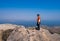 Happy Asian man standing with happy smile and thumb up on top viewpoint on rock mountain peak with misty lake dam view and blue