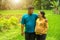 Happy Asian maternity couple looking at each other, over tropical farm land