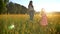 Happy asian mother with daughter are walking in field in summer, family concept, side view