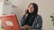 Happy Asian muslim businesswoman female entrepreneur making business phone call while working at home