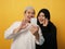 Happy Asian muslim couple doing video call on smart phone, husband and wife looking at phone, smiling and waving gesture