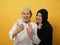 Happy Asian muslim couple doing video call on smart phone, husband and wife looking at phone, smiling and waving gesture