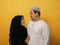 Happy Asian muslim couple hugging embracing each other, husband and wife love romance relationship over yellow